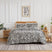 Front view of Khari duvet cover set showcasing slate abstract pattern on a bed with a rattan headboard