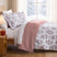 Merry Manor duvet cover set styled on a Christmas bed with white floral print, red striped reverse, matching shams, and festive decor.